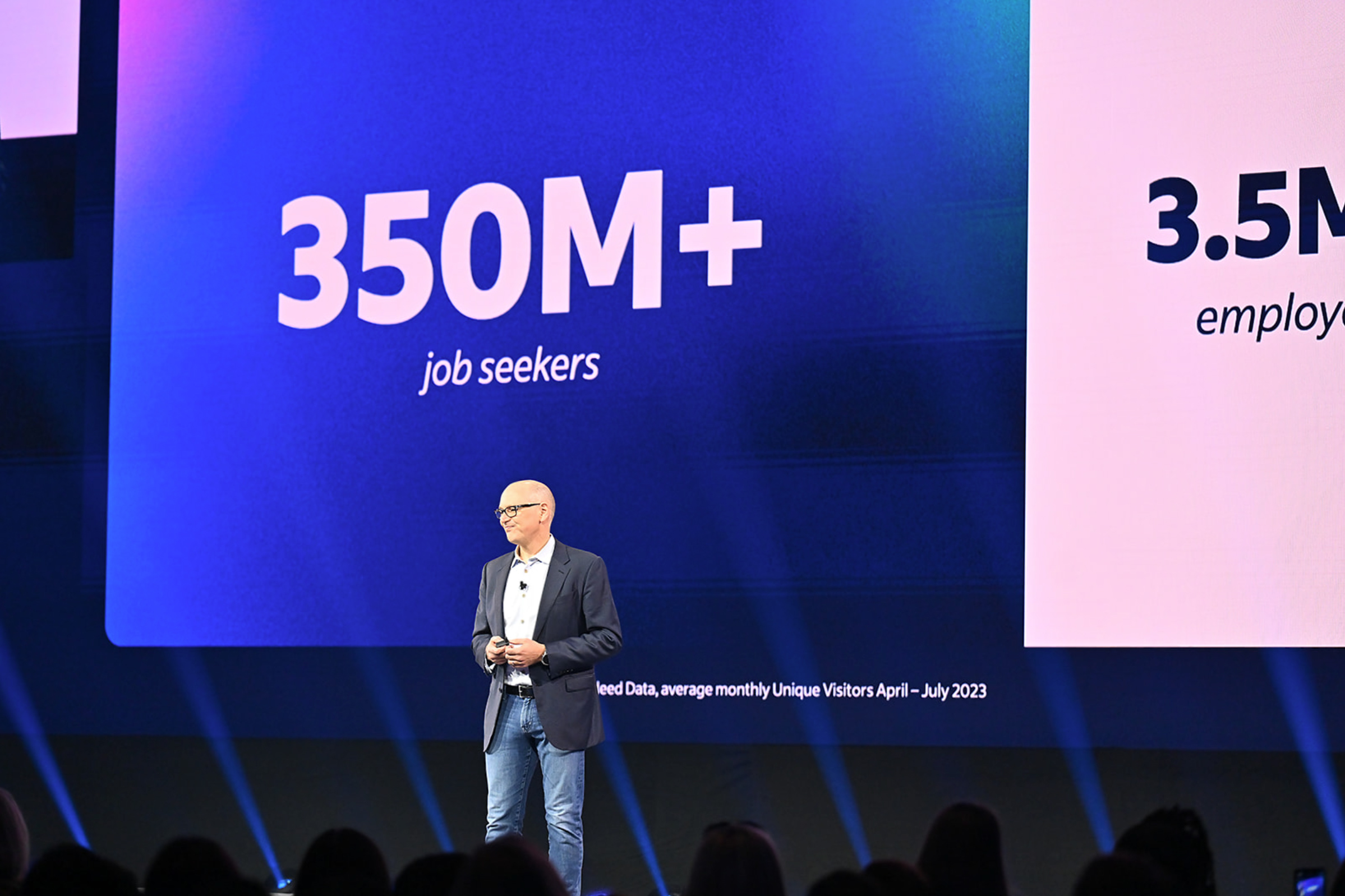 CEO on stage presenting deck slide