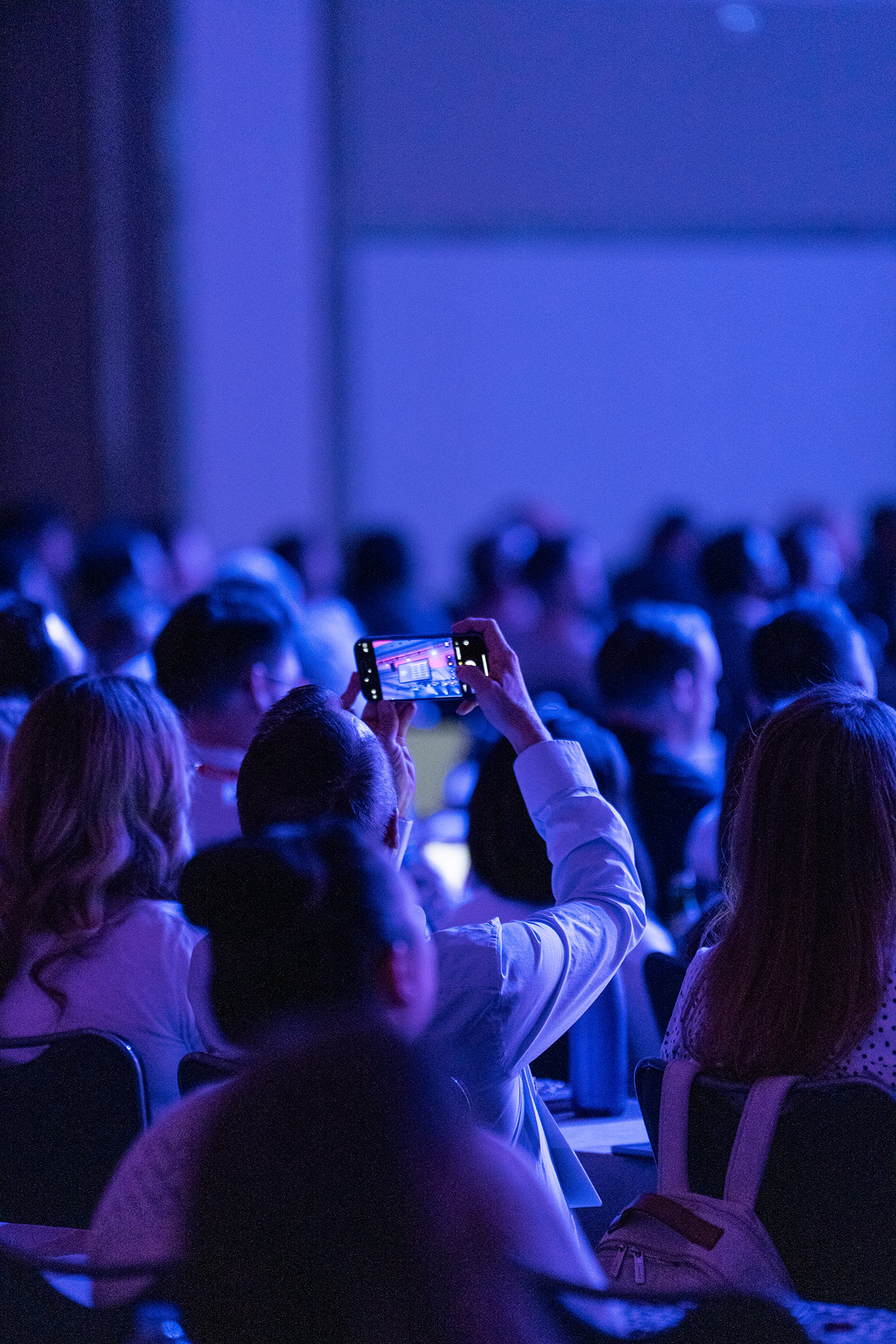 Audience member photographing presentation slide